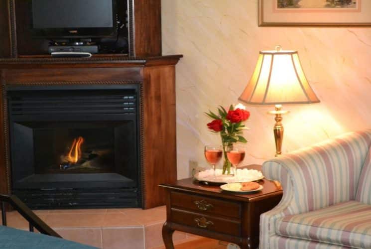 Sitting area with loveseat, side table with wine, and gas fireplace