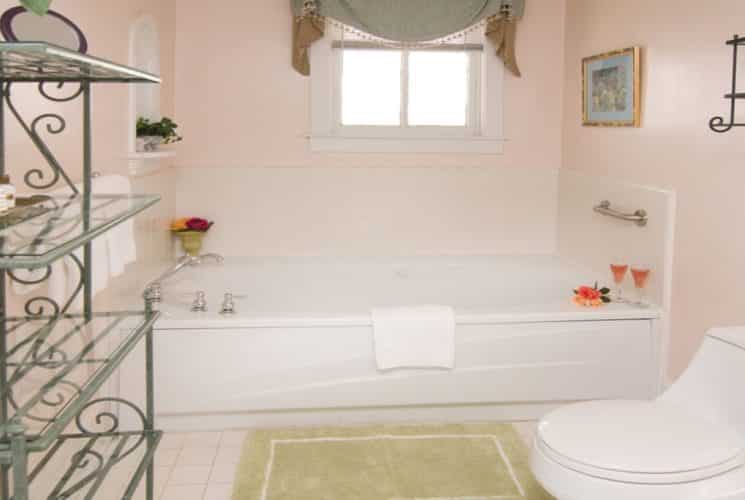 Bathroom with large soaker tub, curtained window and toilet