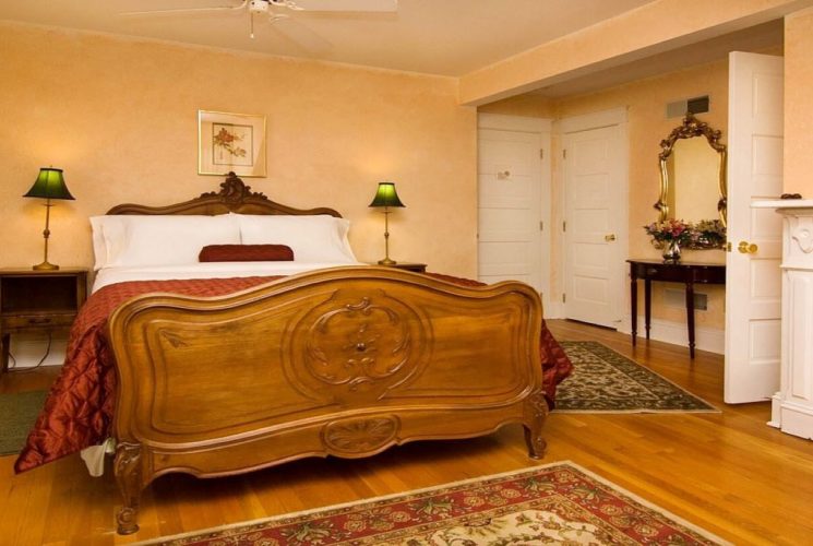 Bedroom with antique queen bed, gas fireplace and hardwood floors